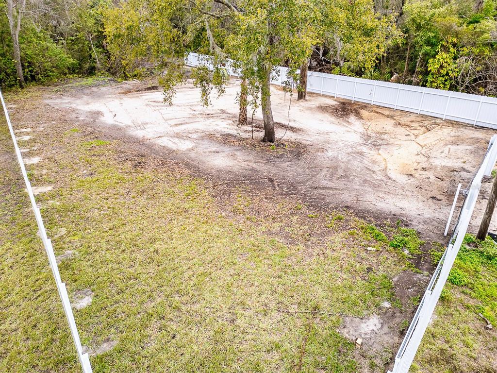 An elevated view of a fenced, partially cleared residential lot with several mature trees — 3837 STREAMSIDE LANE, NEW PORT RICHEY, FL