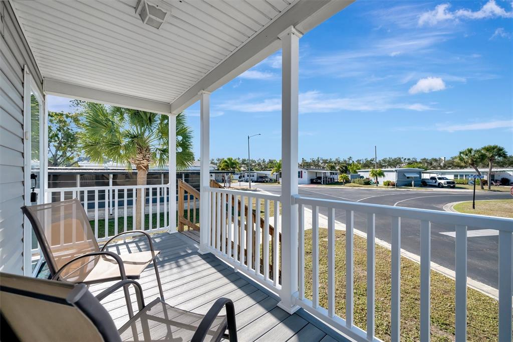 A covered porch with white railings overlooks a paved street and neighborhood homes — 105 W SAINT JOHNS WAY, APOLLO BEACH, FL