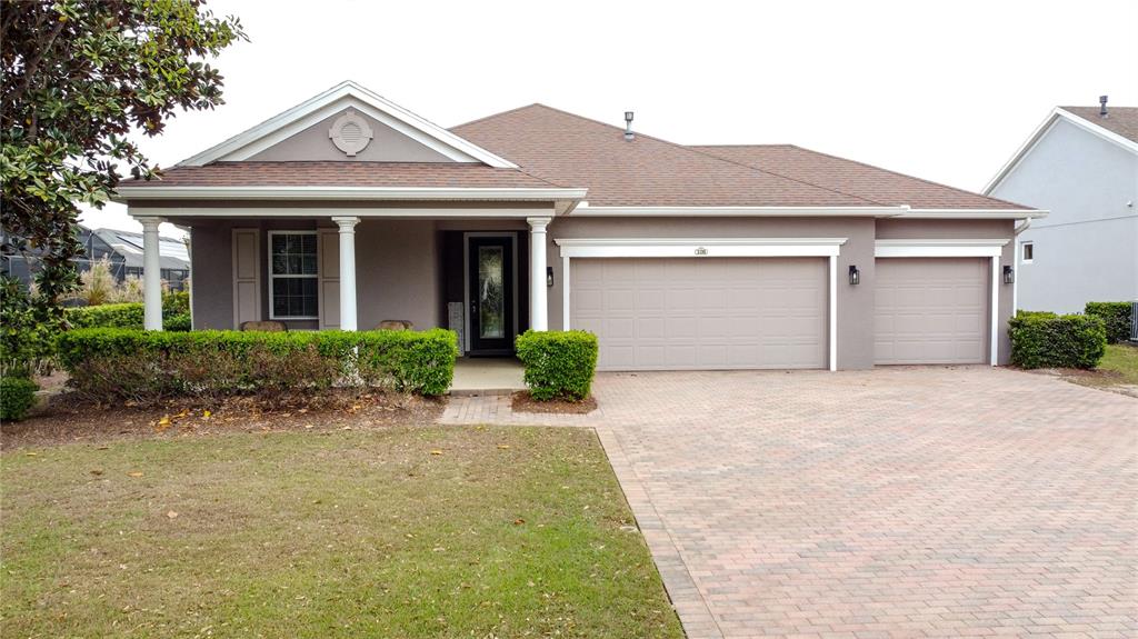 A single-story house with a brown roof, gray exterior, and a three-car garage — 108 MIST FLOWER LANE, GROVELAND, FL
