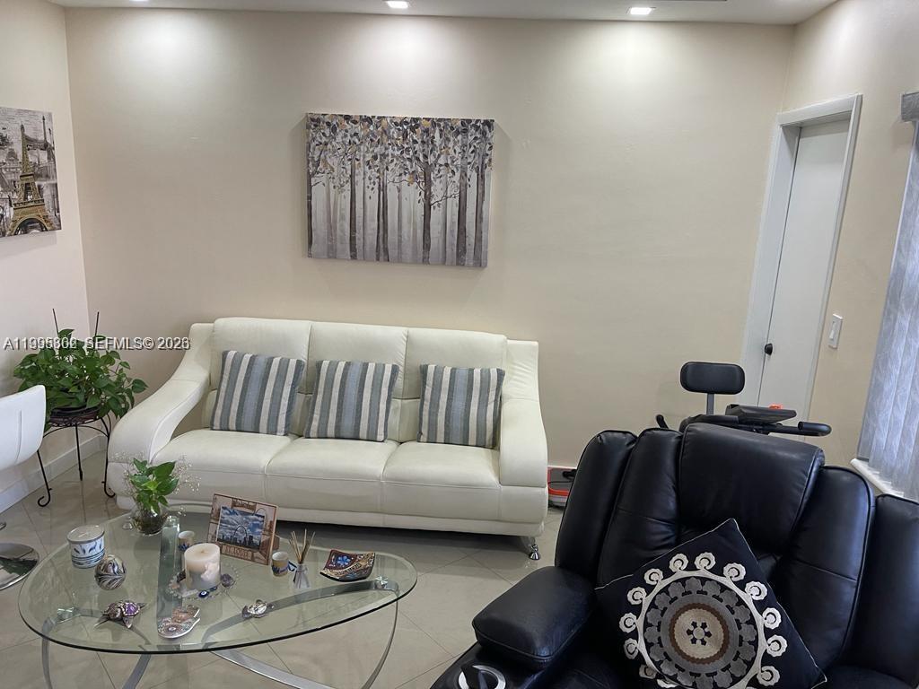 A living room features a white sofa, a glass coffee table, and a black recliner — 3200 NE 7th Ct # 306C, Pompano Beach FL 33062, POMPANO BEACH, FL