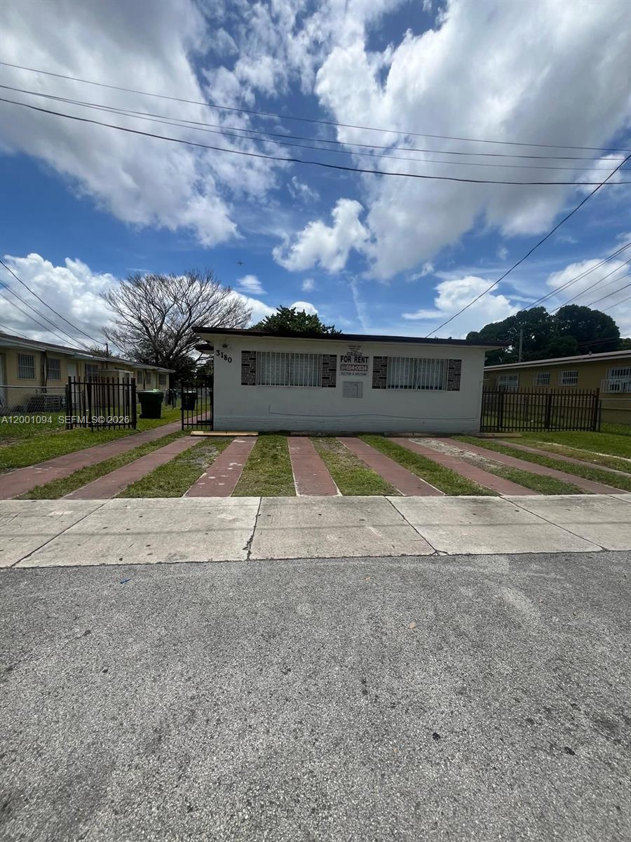 A single-story residential building with a flat roof and a paved driveway in front — 3180 NW 19th Ave, Miami FL 33142, MIAMI, FL