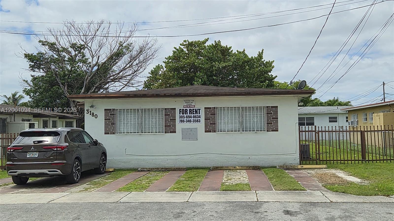 A single-story white house with a brown roof and a car parked in front — 3180 NW 19th Ave, Miami FL 33142, MIAMI, FL