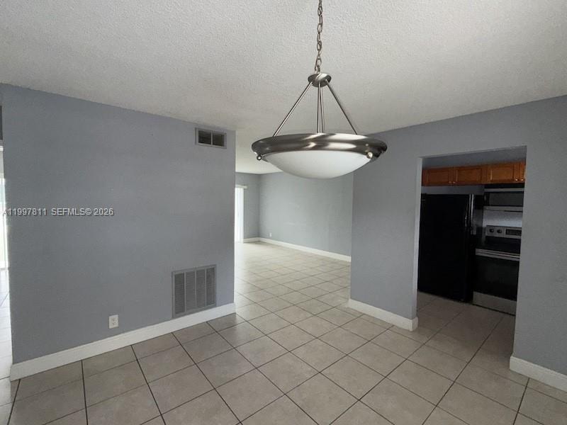A dining area with tile flooring, a pendant light, and an adjacent kitchen — 4251 NW 5th St # 108, Plantation FL 33317, PLANTATION, FL