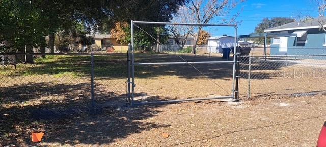 A metal gate stands in a chain-link fence enclosing a vacant, grassy lot — 0 PEARL STREET, LAKE WALES, FL