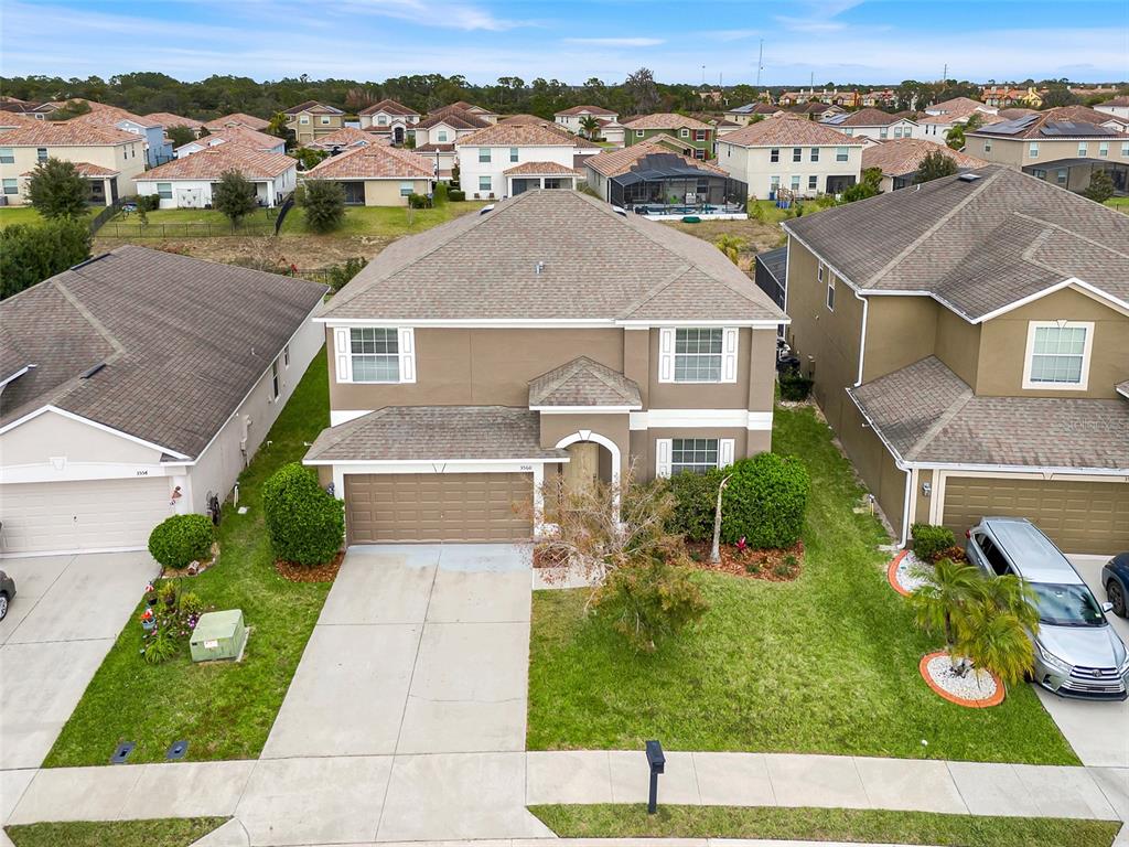 An aerial view shows a two-story suburban house with a tan exterior and brown roof — 3560 CORTLAND DRIVE, DAVENPORT, FL