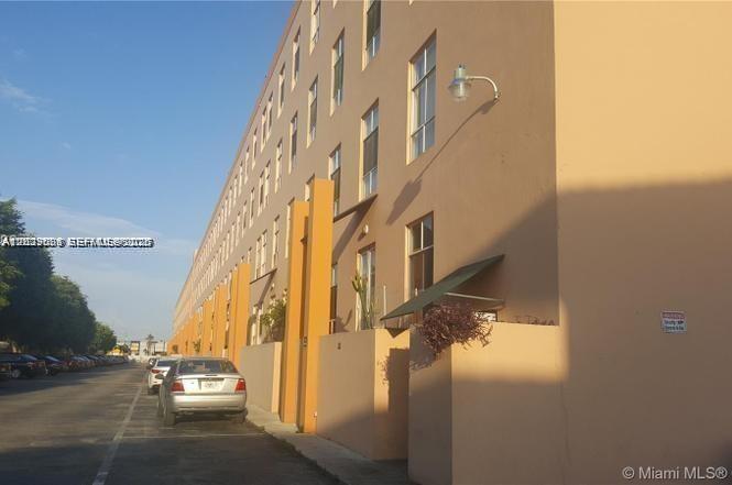 A multi-story tan apartment building exterior with a parking lot and parked cars — 7420 W 20th Ave # 151, Hialeah FL 33016, HIALEAH, FL