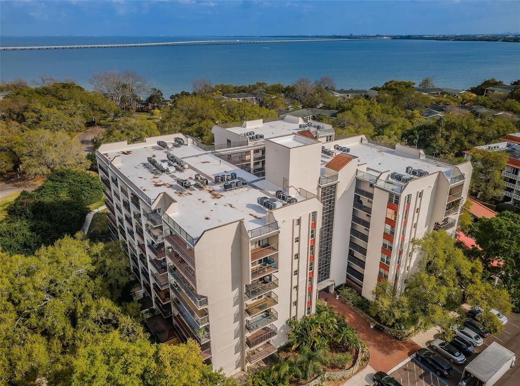 An aerial view of a multi-story apartment building situated near a large body of water — 2699 SEVILLE BOULEVARD UNIT 105, CLEARWATER, FL