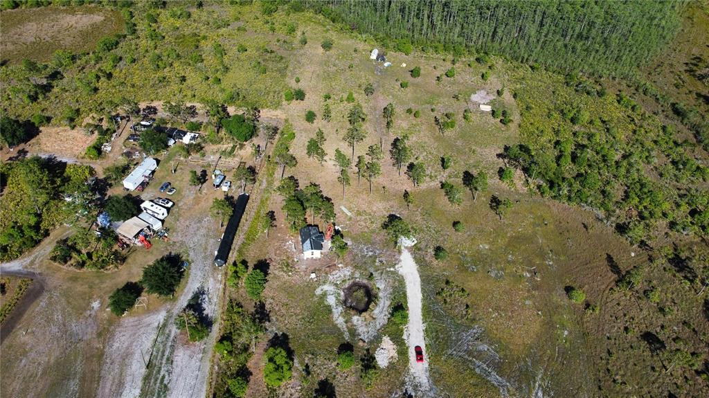 An aerial view shows a rural property with a house, outbuildings, and a gravel driveway — HARRIS ROAD, ST CLOUD, FL