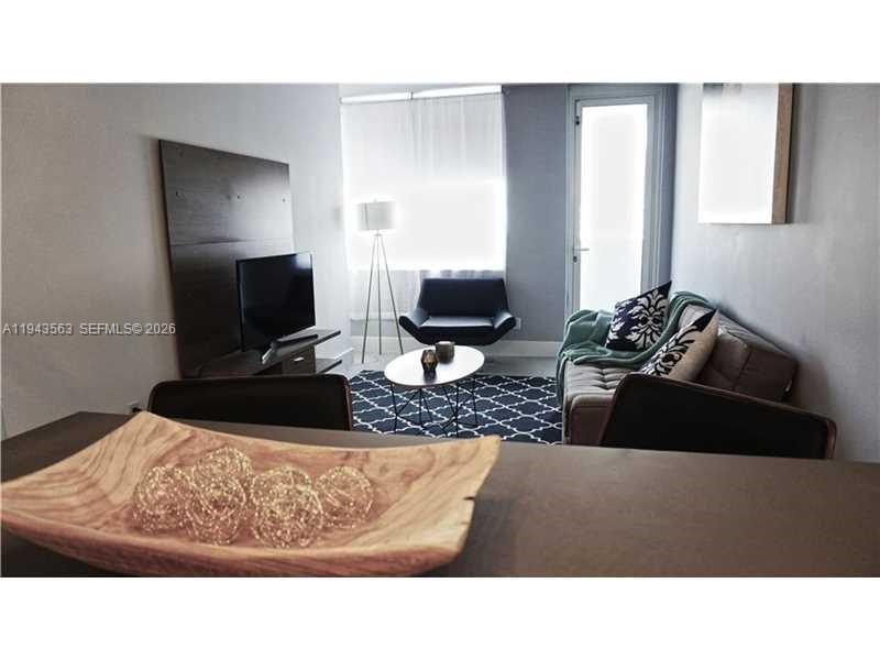 A living room features a television on a stand, a sofa, and a coffee table — 100 Lincoln Rd # 420, Miami Beach FL 33139, MIAMI BEACH, FL