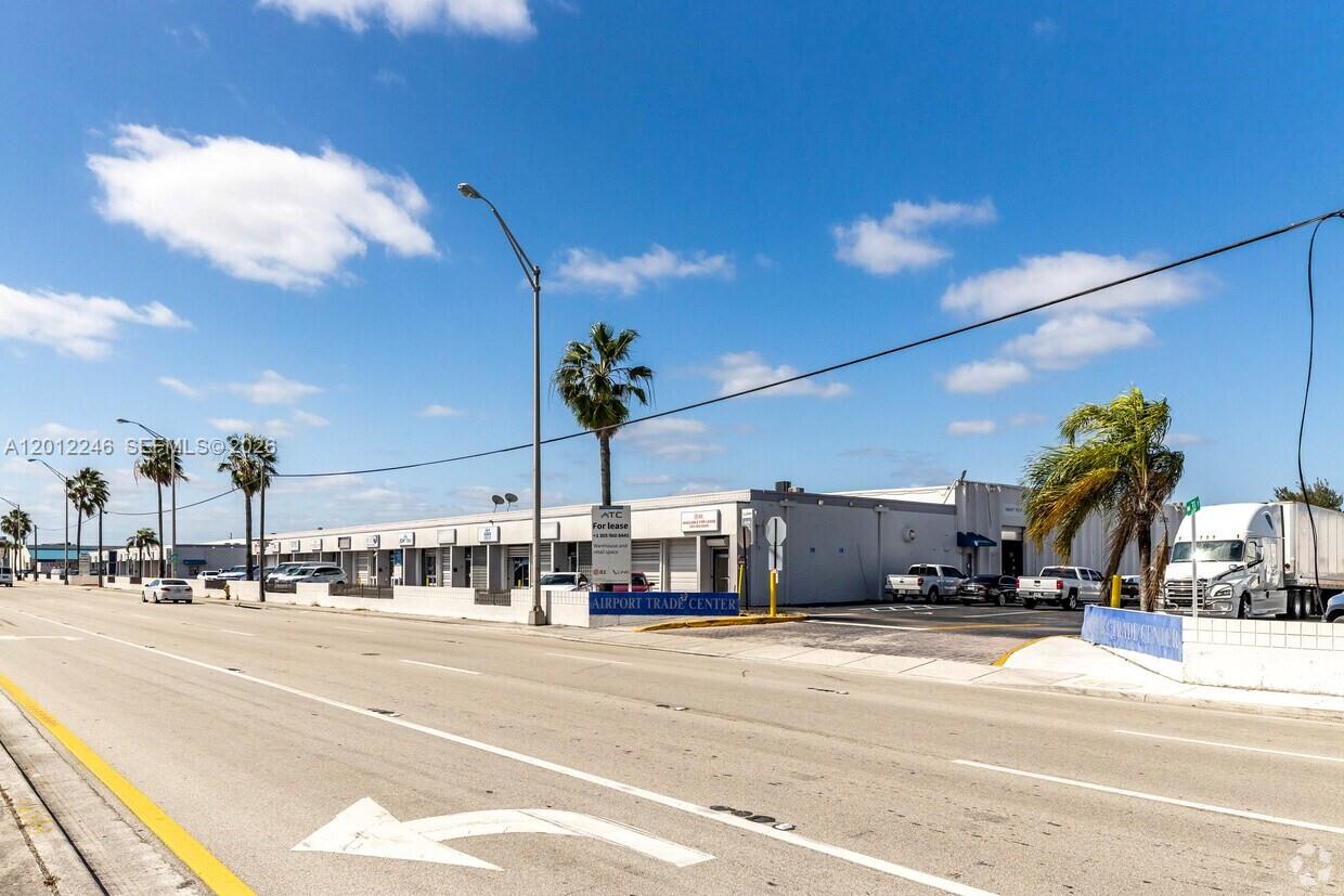 An exterior view of a commercial warehouse complex with a parking lot and palm trees — 3108 NW 72nd Ave, Miami FL 33122, MIAMI, FL