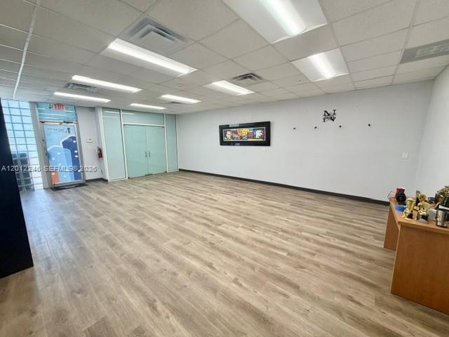 An empty office space features light wood-look flooring, recessed ceiling lights, and a glass door — 3108 NW 72nd Ave, Miami FL 33122, MIAMI, FL
