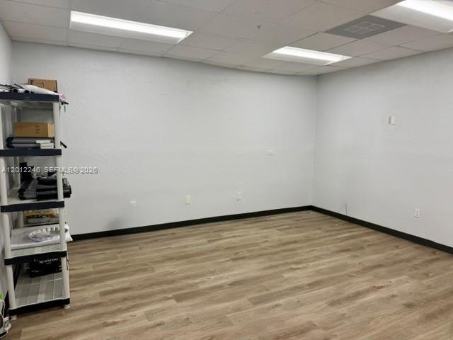 An empty office room features light wood-look flooring, white walls, and a drop ceiling — 3108 NW 72nd Ave, Miami FL 33122, MIAMI, FL