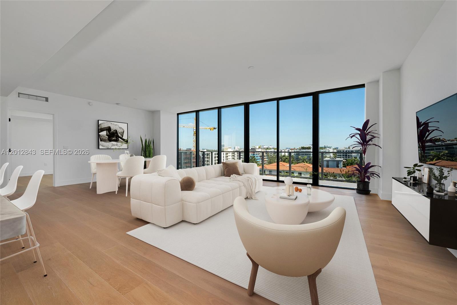 A modern living and dining area features light wood floors, floor-to-ceiling windows, and neutral furniture — 1176 97th St # 809, Bay Harbor Islands FL 33154, BAY HARBOR ISLANDS, FL