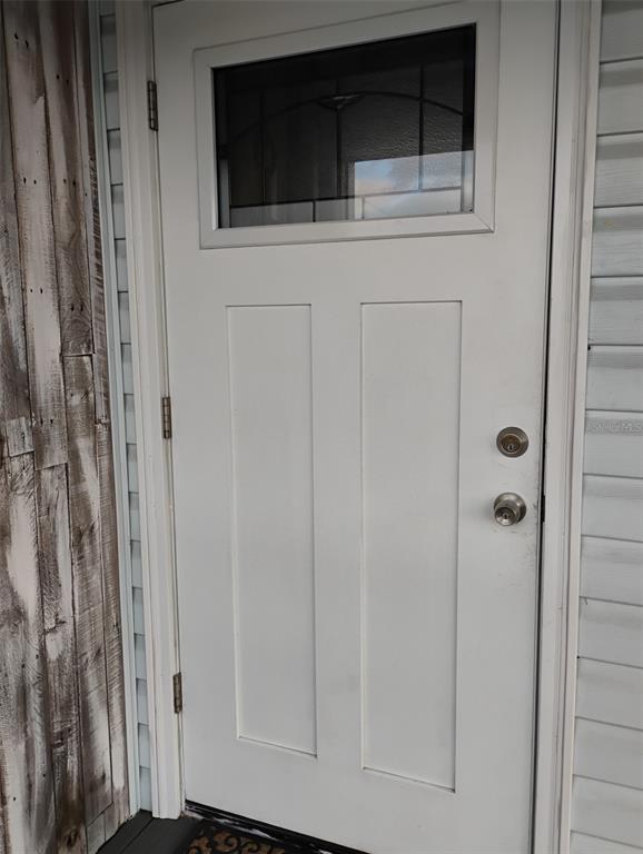 A white exterior door with a rectangular window panel and two lower vertical recessed panels — 6728 SEA RANCH DR, HUDSON, FL