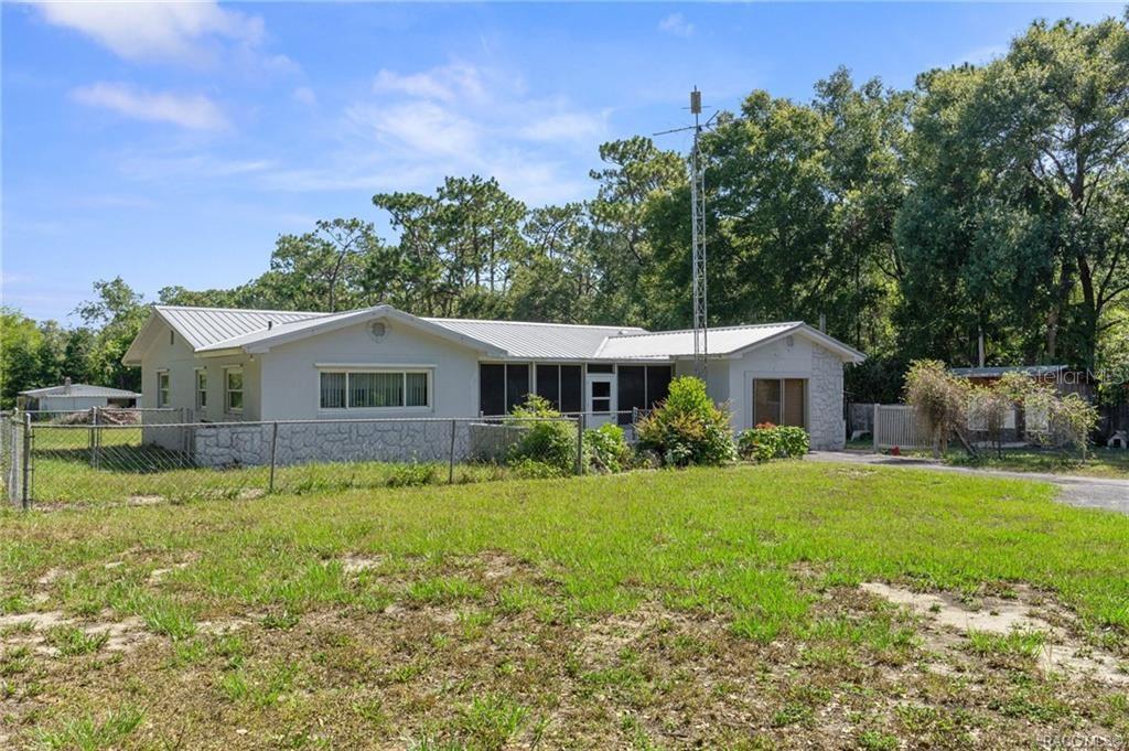 A single-story house with a metal roof, screened porch, and chain-link fence in a yard — 7251 W LACEY LANE, HOMOSASSA, FL
