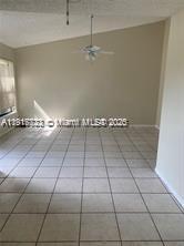An empty room with light-colored tile flooring, a vaulted ceiling, and a ceiling fan — 1314 White Pine Dr # B, Wellington FL 33414, WELLINGTON, FL