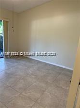 An empty room features light-colored walls and large, neutral-toned floor tiles — 1314 White Pine Dr # B, Wellington FL 33414, WELLINGTON, FL