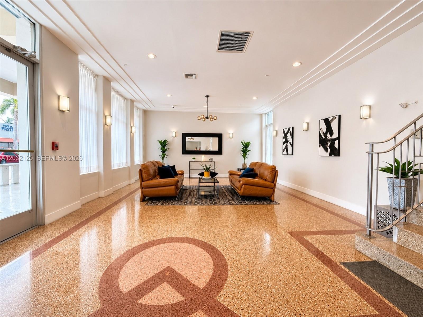 A lobby features two leather sofas, a patterned rug, and a decorative terrazzo floor — 7326 Collins Ave # 203, Miami Beach FL 33141, MIAMI BEACH, FL