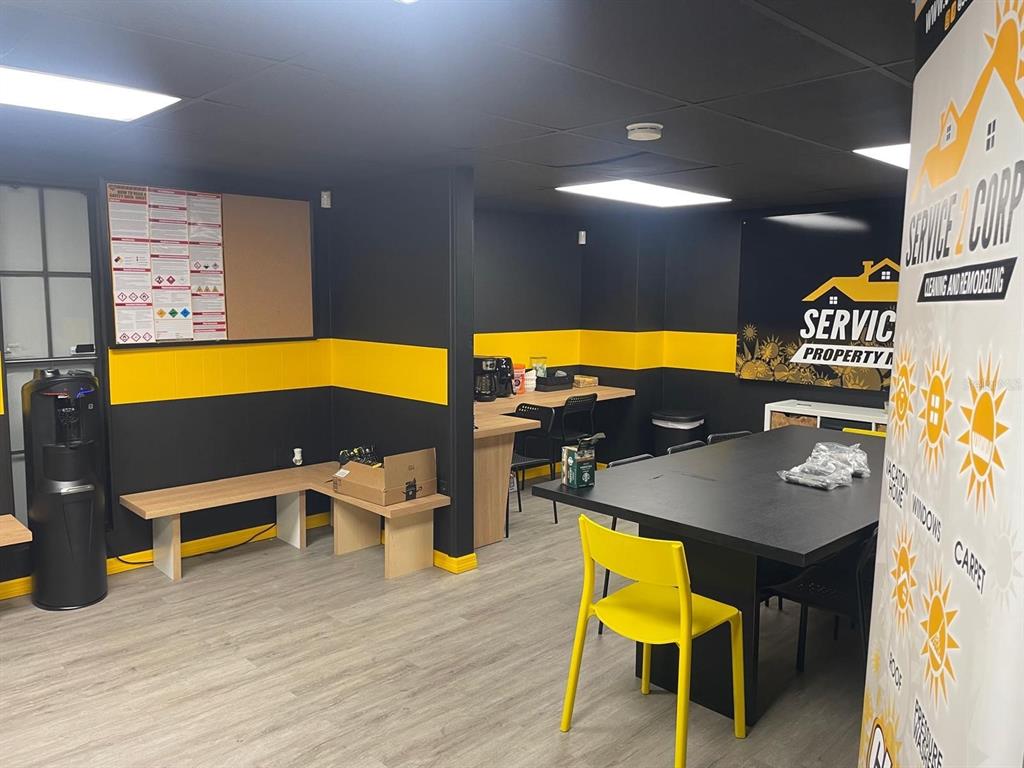 An office space features black and yellow walls, a conference table, and a water cooler — 1210-1232 DYER BOULEVARD UNIT 1214, KISSIMMEE, FL