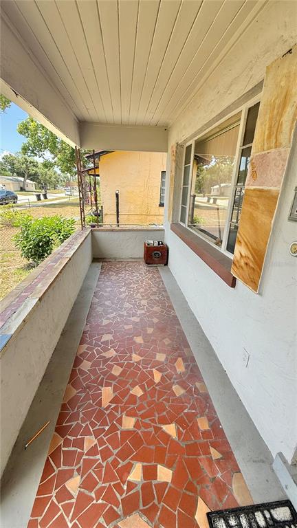 A covered porch features a mosaic tile floor and a large window on the exterior wall — 2055 29TH STREET S, ST PETERSBURG, FL