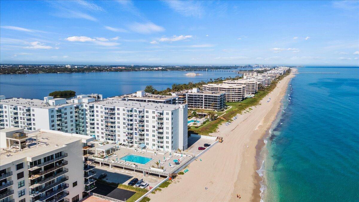 An aerial view shows multiple beachfront apartment buildings along a sandy coastline next to water — 3450 S Ocean Boulevard # 8120, Palm Beach FL 33480, PALM BEACH, FL