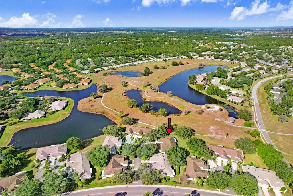 An aerial view shows a residential home with a red arrow pointing toward its roof — 2608 NEWCOMB COURT UNIT 2608, SUN CITY CENTER, FL