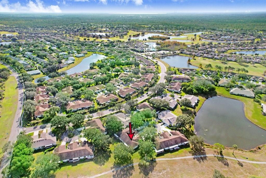 An aerial view of a residential neighborhood featuring houses, ponds, and green spaces — 2608 NEWCOMB COURT UNIT 2608, SUN CITY CENTER, FL