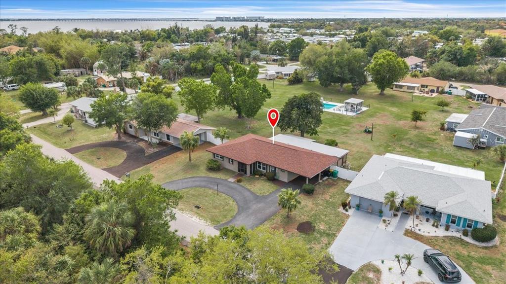 An aerial view shows a single-story house with a red roof and a circular driveway — 4085 DRANCE STREET, PUNTA GORDA, FL