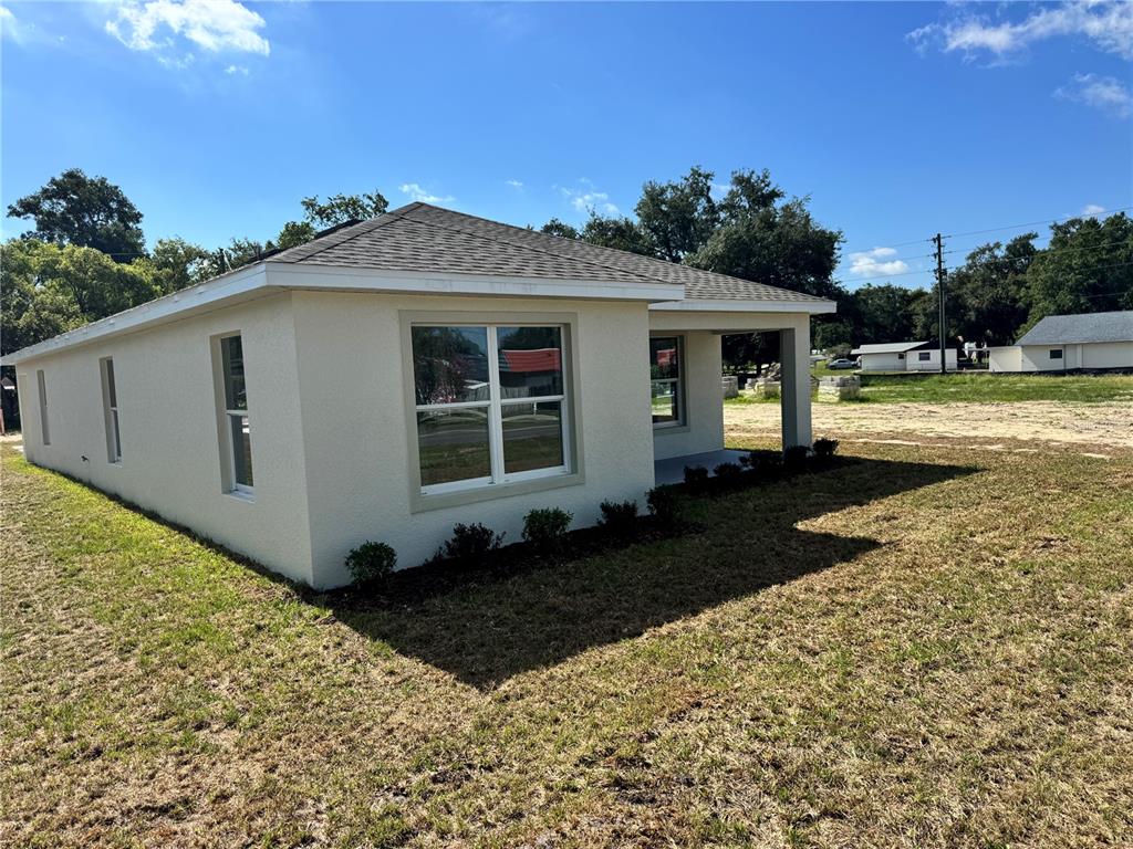 A light-colored, single-story house with a hip roof and a small front porch — 6020 12TH STREET, ZEPHYRHILLS, FL