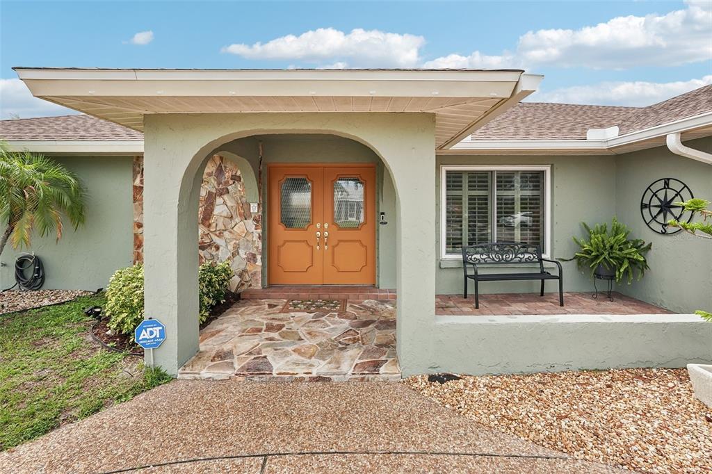 The exterior of a house features a stone-paved entryway with orange double doors — 1201 JAMAICA ROAD, VENICE, FL