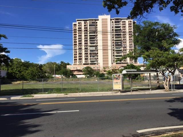 A tall residential building stands behind a vacant, fenced lot next to a bus stop — 359 FERNANDEZ JUNCOS AVENUE, SAN JUAN, PR