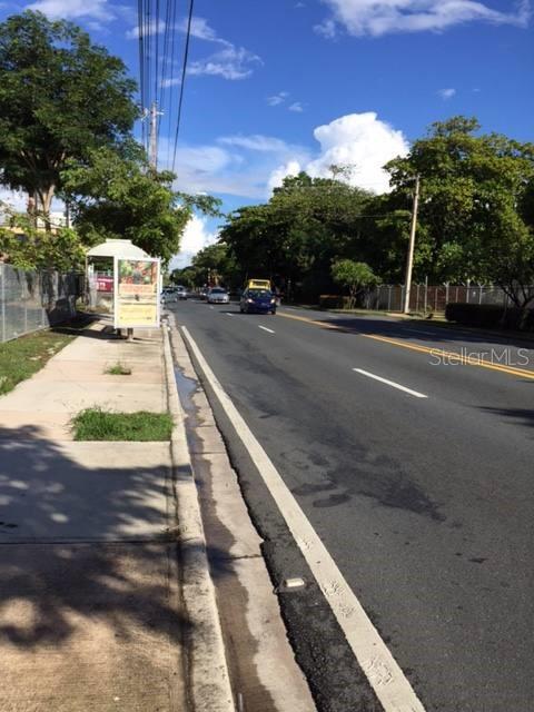 A view of a paved road with a bus stop and trees under a blue sky — 359 FERNANDEZ JUNCOS AVENUE, SAN JUAN, PR