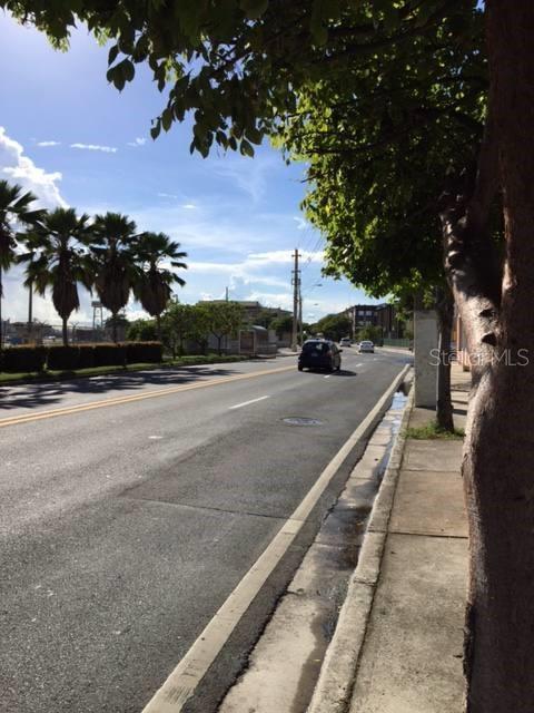 A paved road stretches into the distance, lined by palm trees and a sidewalk — 359 FERNANDEZ JUNCOS AVENUE, SAN JUAN, PR