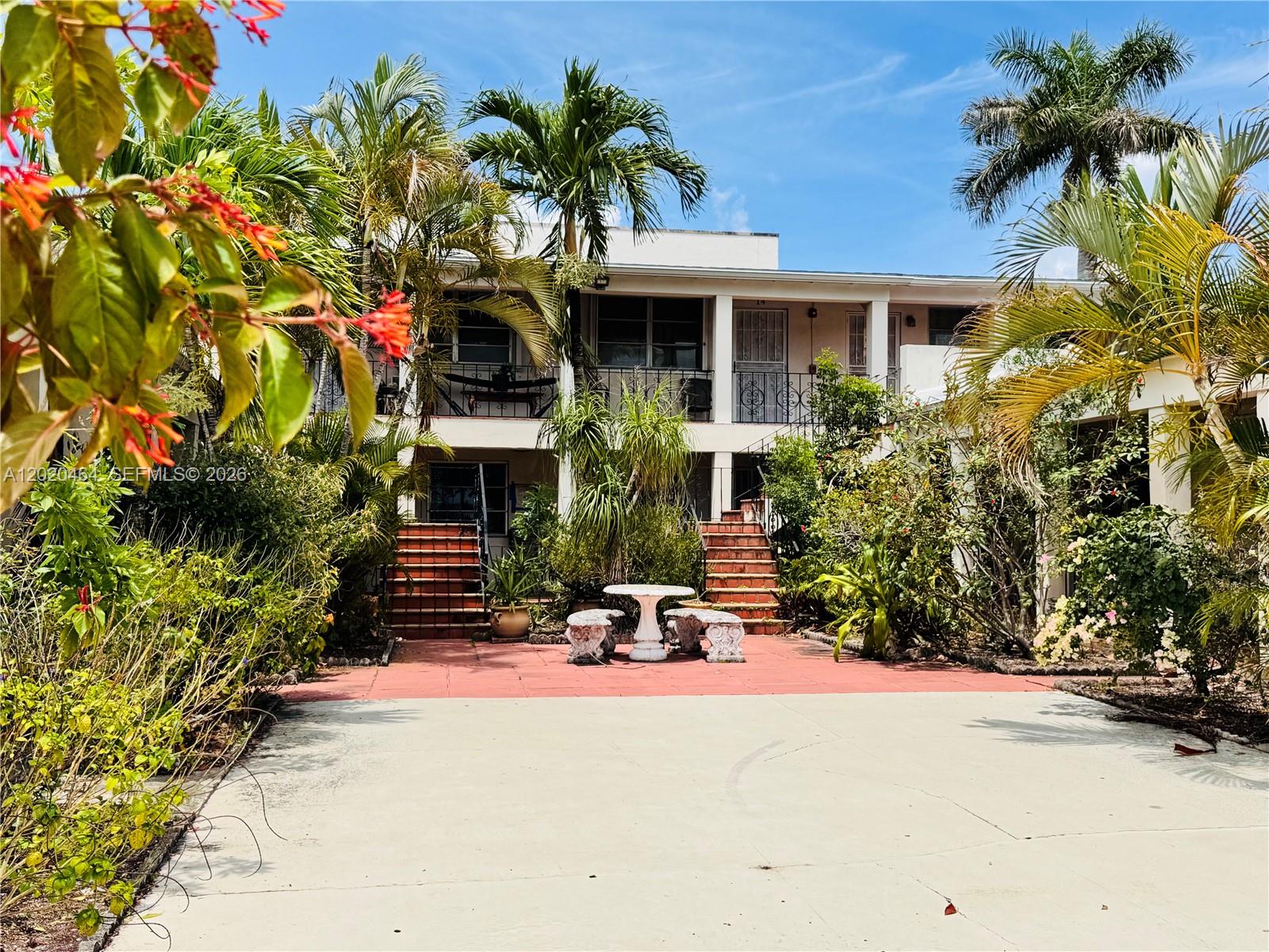 A two-story apartment building with a central courtyard, outdoor seating, and tropical landscaping — 756 N 17th Ave # 15, Hollywood FL 33020, HOLLYWOOD, FL