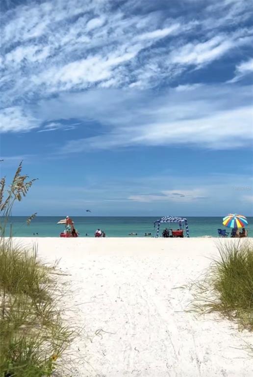 A sandy path leads to a beach with umbrellas, a canopy, and the ocean — 411 LACKLAND STREET, PORT CHARLOTTE, FL