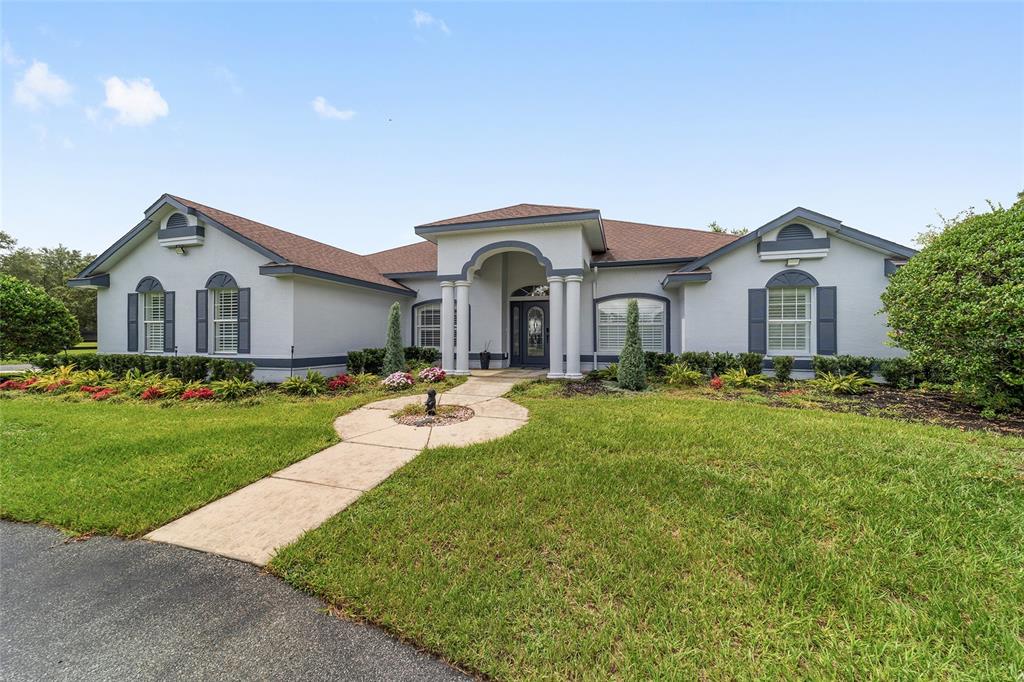 A single-story house with a white stucco exterior, gray shutters, and a covered front entrance — 6208 NW 12TH STREET, OCALA, FL