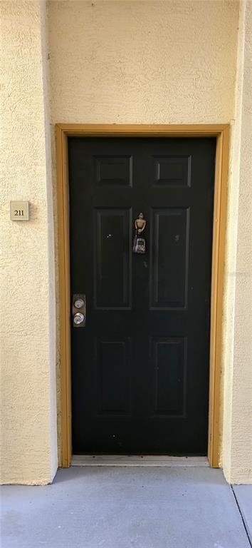 A dark-colored front door with a door knocker and a unit number sign — 5618 PINNACLE HEIGHTS CIRCLE UNIT 211, TAMPA, FL