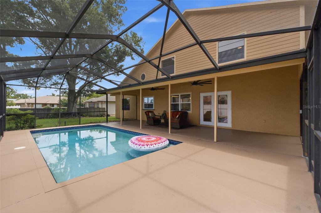 A stone fireplace with a black marble hearth and glass doors stands against a white wall — 5509 GANNETT COURT, NEW PORT RICHEY, FL