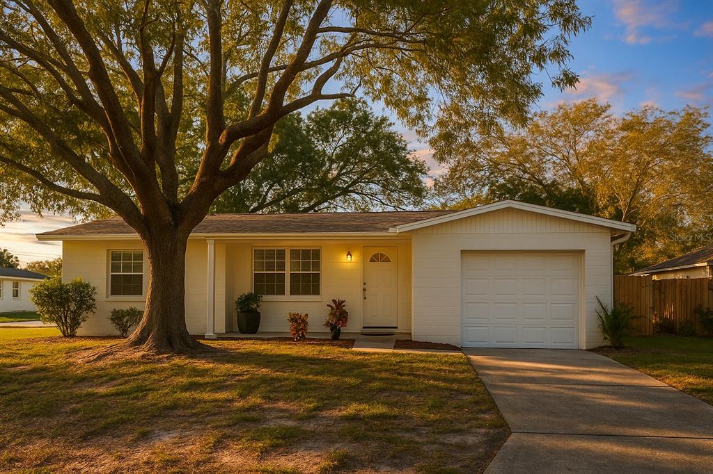 A single-story house with white siding, a front porch, and an attached garage under trees — 5008 27TH AVENUE W, BRADENTON, FL