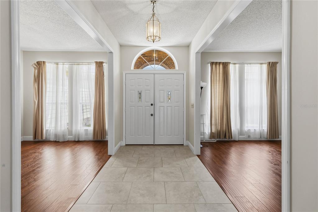 A foyer with tile flooring leads to a white double door with a transom window — 1572 HUNTERS STAND RUN, OVIEDO, FL