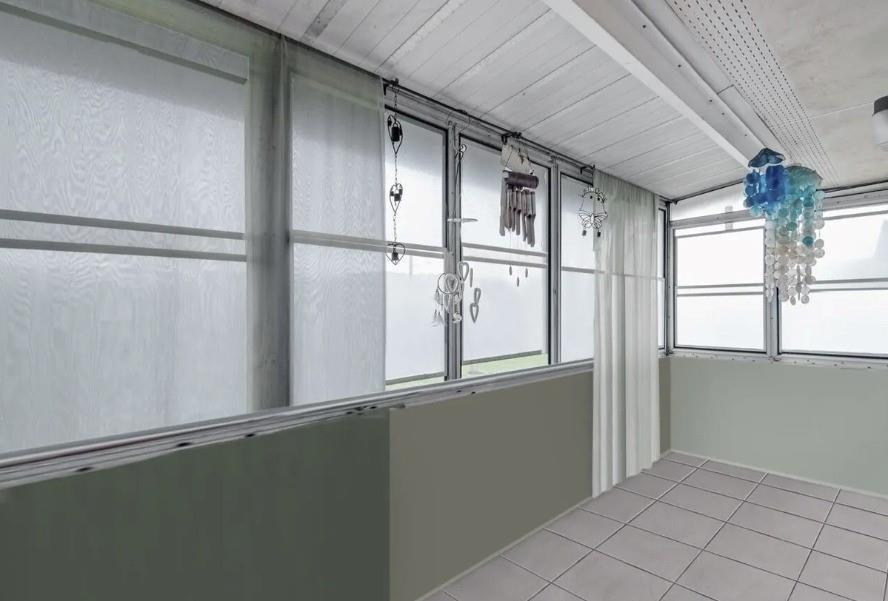 A sunroom with white tile flooring, large windows, hanging decor, and light green wall panels — 223 Flanders, Delray Beach FL 33484, DELRAY BEACH, FL
