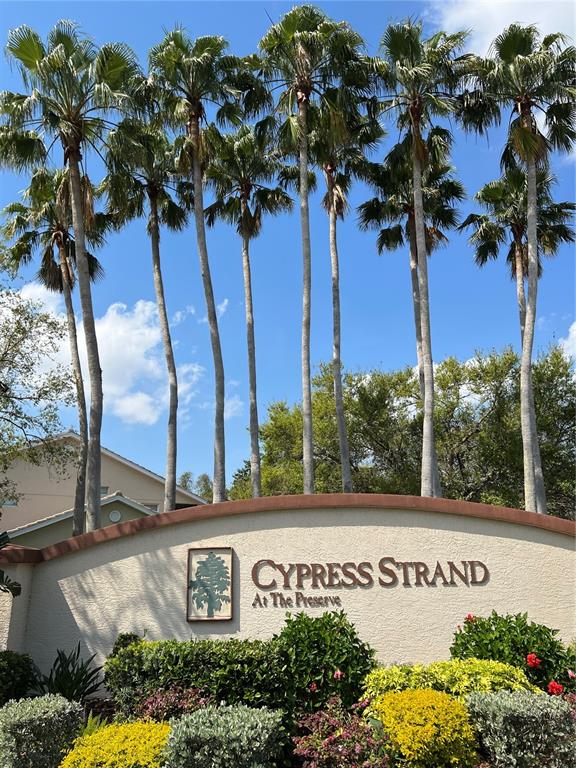 A stucco monument sign for Cypress Strand at The Preserve stands before tall palm trees — 7060 STRAND CIRCLE UNIT 7060, BRADENTON, FL