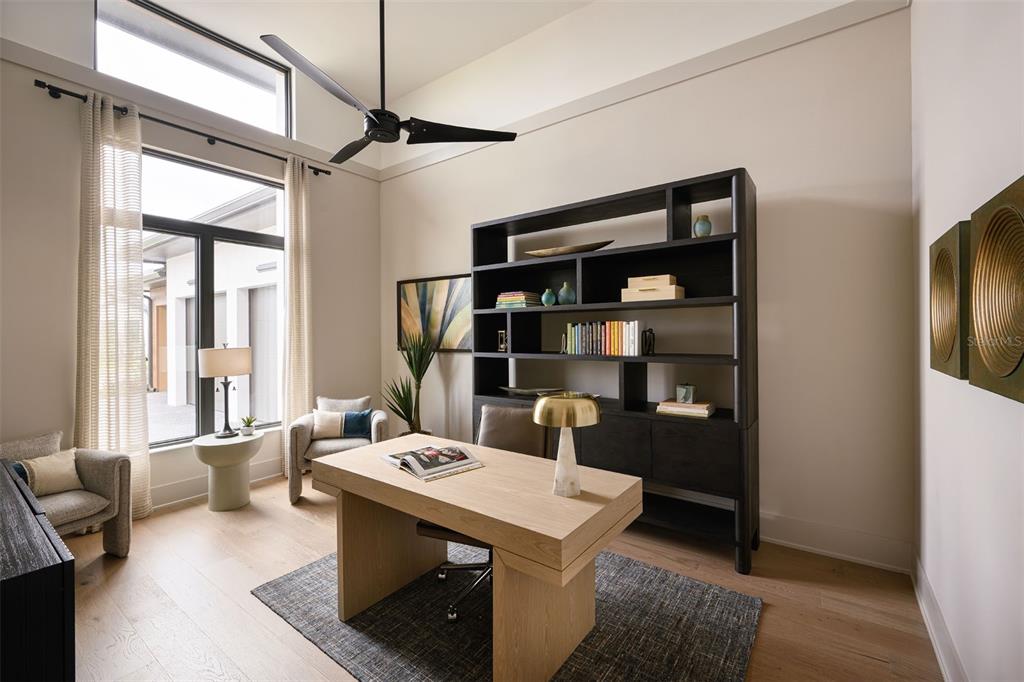 A home office features a light wood desk, a dark bookshelf, and two armchairs — 263 CRYSTAL WATERS DRIVE, SARASOTA, FL