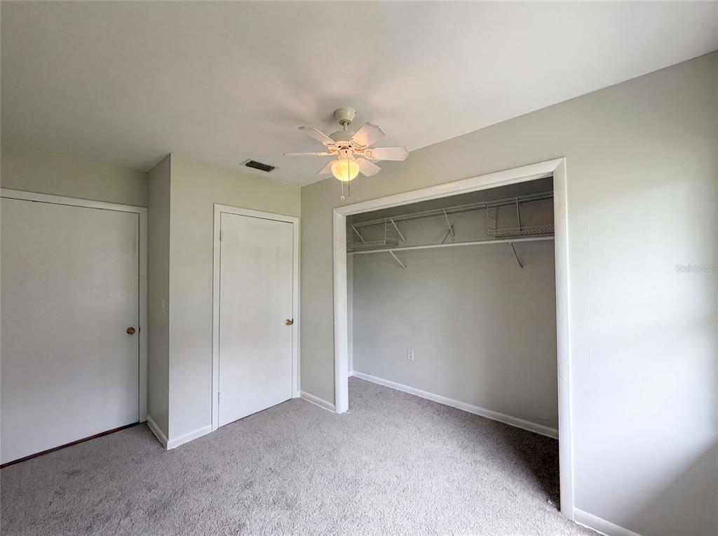 A bedroom features gray carpet, light-colored walls, two closed doors, and an open closet — 2630 SE 8TH AVENUE, OCALA, FL