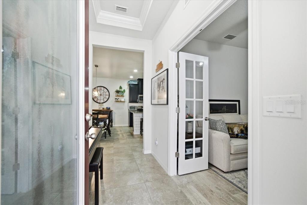 A view from an entryway looking into a kitchen and a room with French doors — 10591 HERON HIDEAWAY LOOP, LAND O LAKES, FL