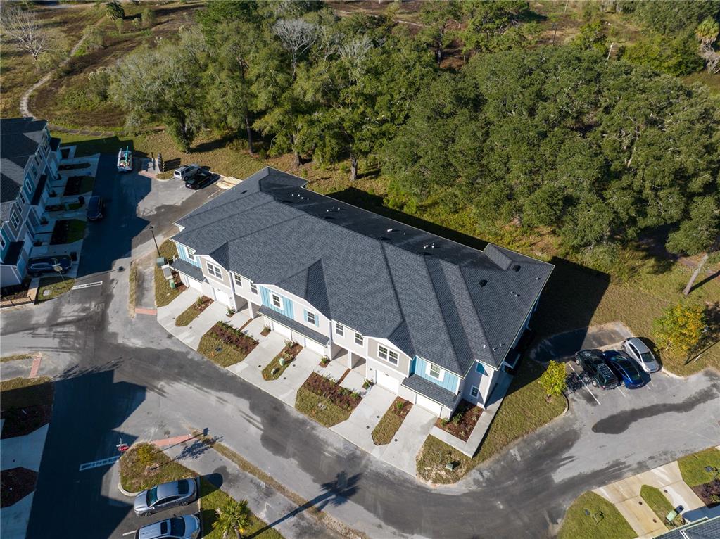 An aerial view shows a multi-unit townhouse building with a dark shingled roof — 704 NW 126TH TERRACE, NEWBERRY, FL