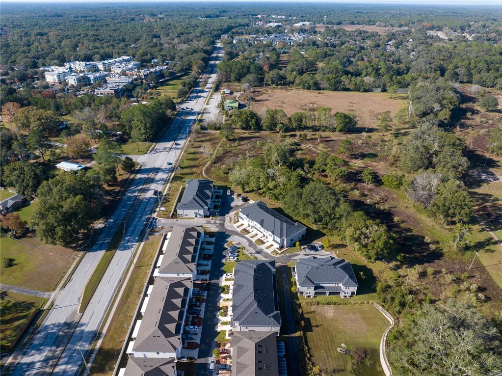 An aerial view shows a multi-unit residential complex situated next to a multi-lane road — 704 NW 126TH TERRACE, NEWBERRY, FL