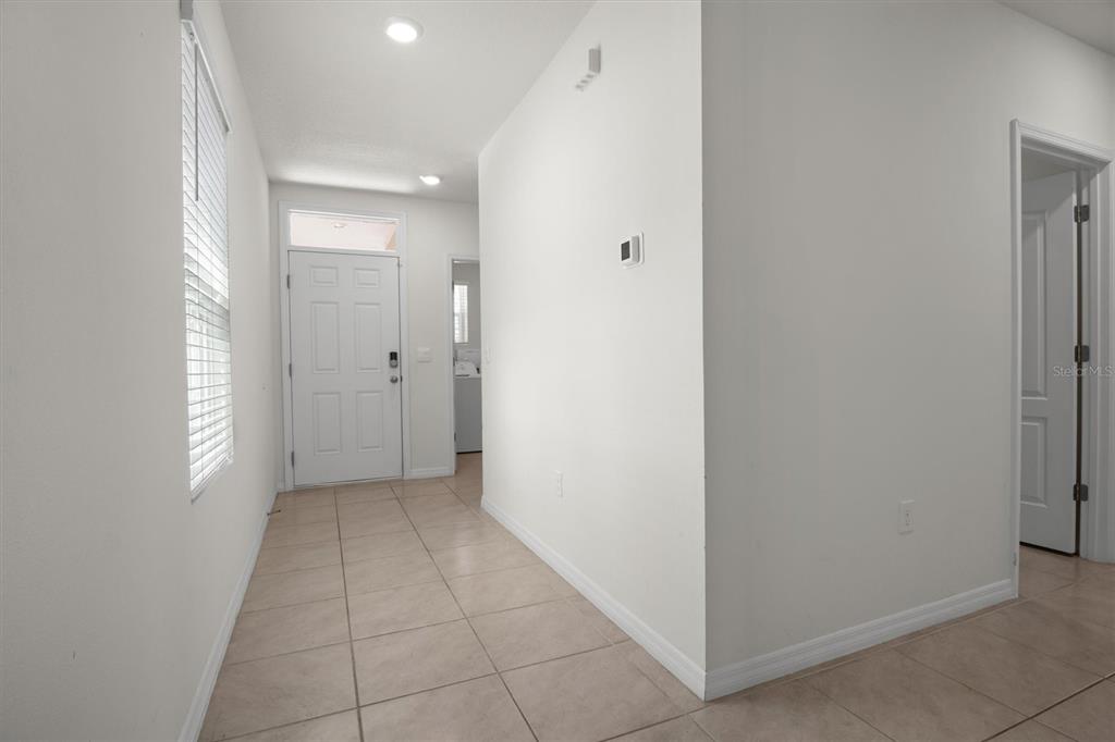 A tiled entryway leads to a white front door with a window above it — 1038 VICTORIA PARC AVENUE, ORANGE CITY, FL