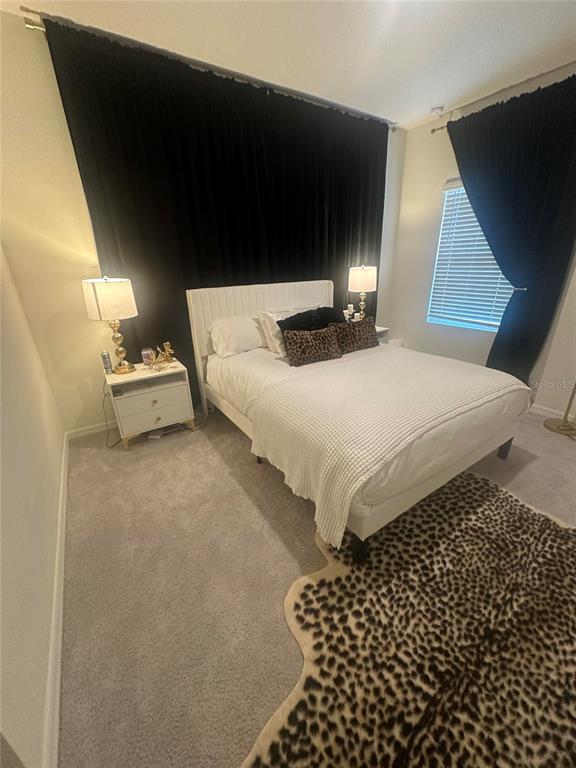 A bedroom features a white bed, black floor-to-ceiling curtains, and a leopard-print area rug — 1169 NW 133RD WAY, NEWBERRY, FL