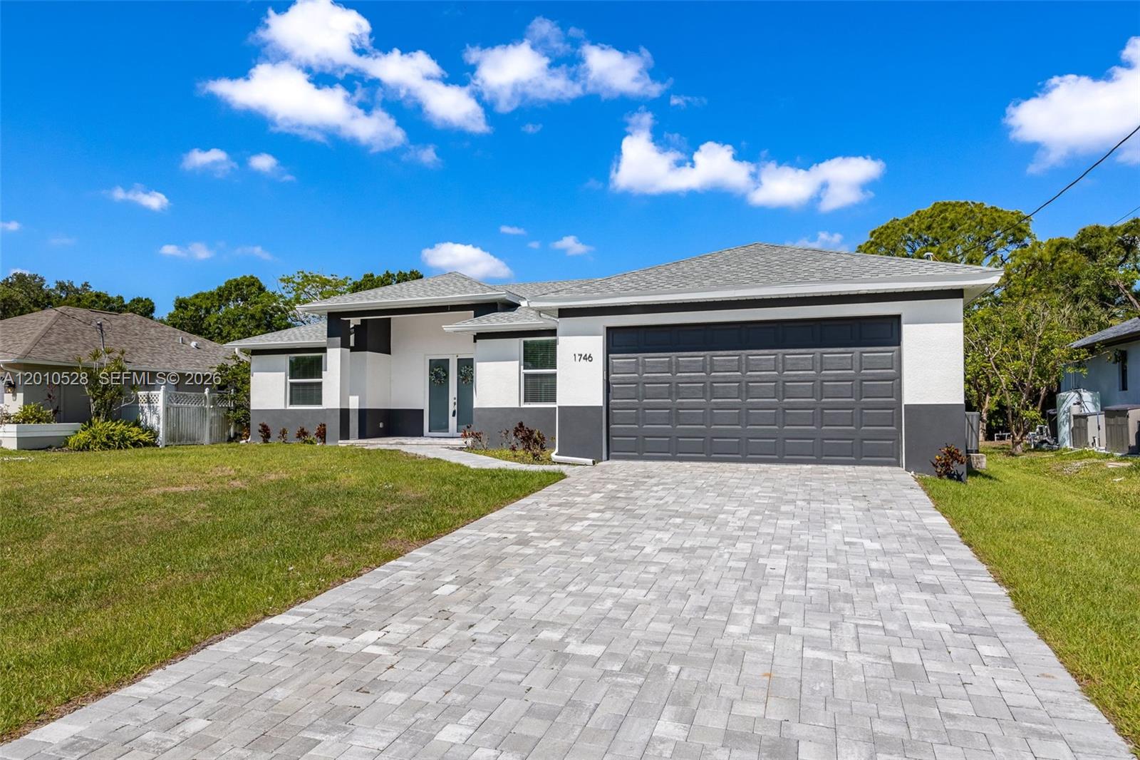 A single-story house features a gray and white exterior with a paved driveway — 1746 NW 26th AVE, Cape Coral FL 33993, CAPE CORAL, FL